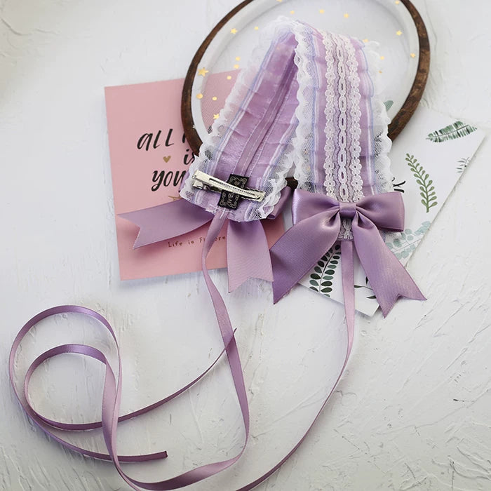 Light-purple double-sided lace hairband with layered trim and a bow laid flat.