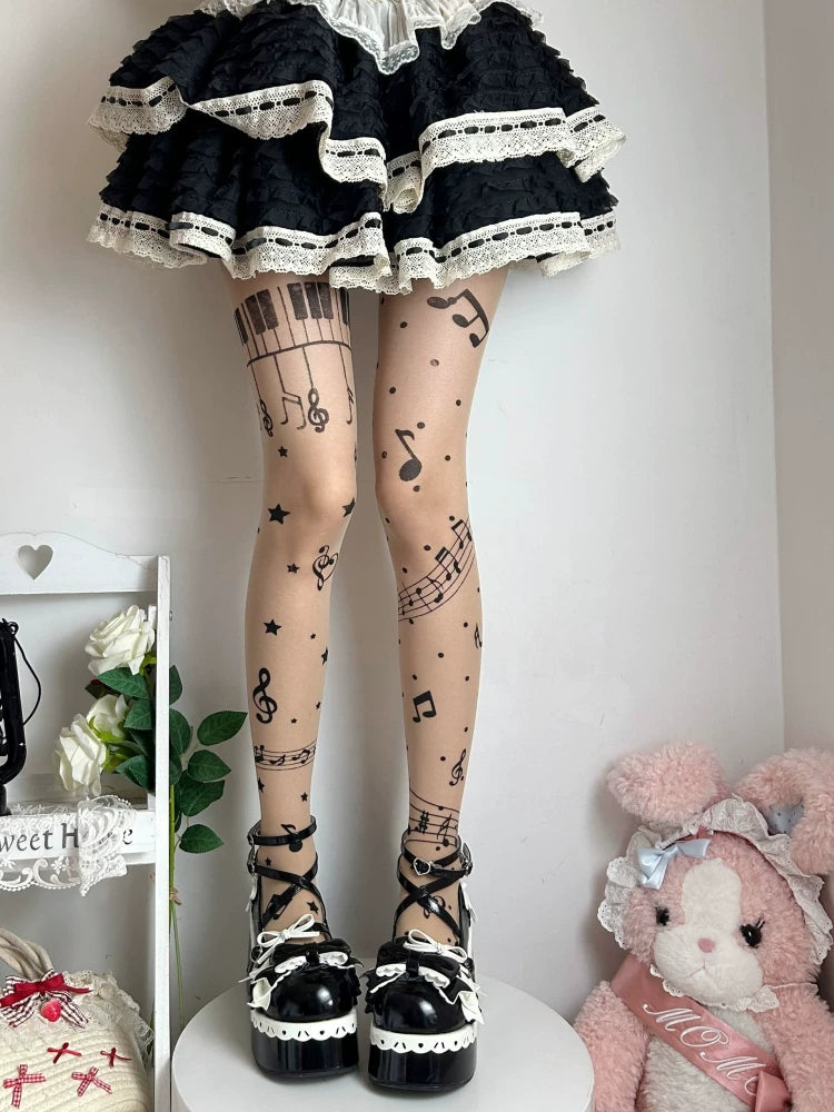 Skin-tone tights with black musical-note, staff, star and piano-key prints styled beneath a black lace-trimmed skirt.