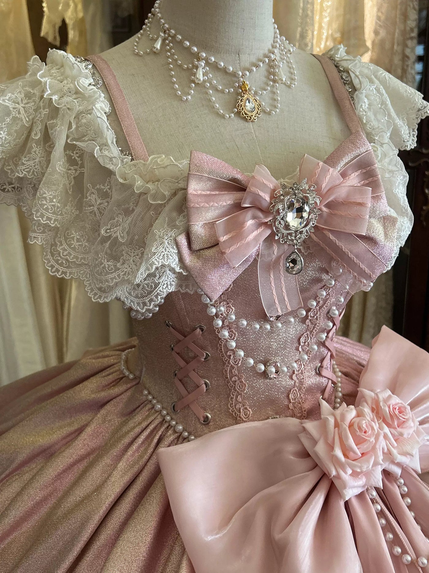 Voluminous pink lolita ball gown with layered skirt and scalloped pearl-trimmed hem