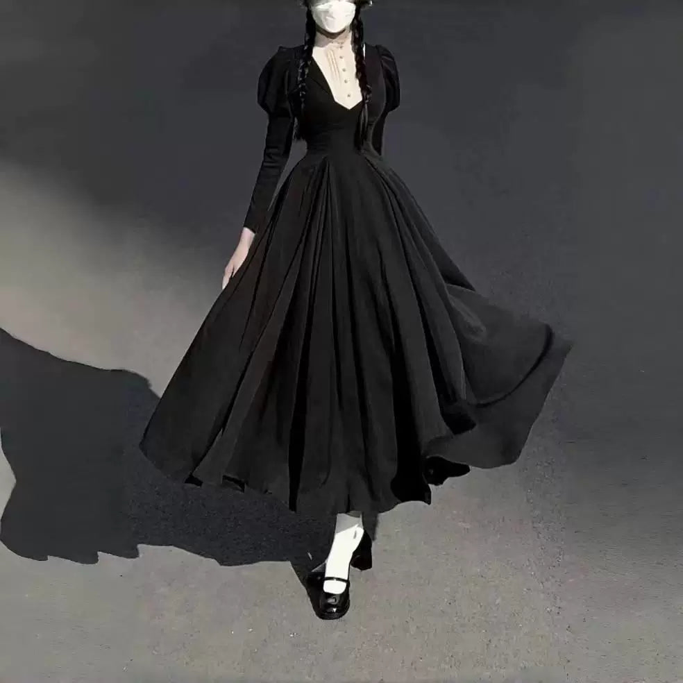 Black long one-piece dress with puff sleeves and a full skirt shown on a model.