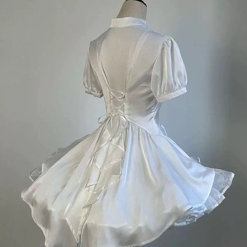 White short-sleeve train blouse shown from the back on a mannequin