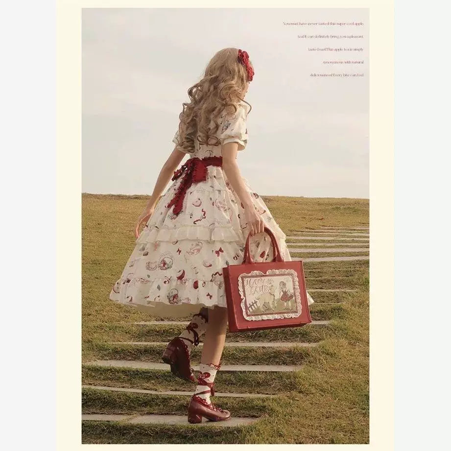 Cream short-sleeve apple-print OP dress shown from the front and back outdoors.