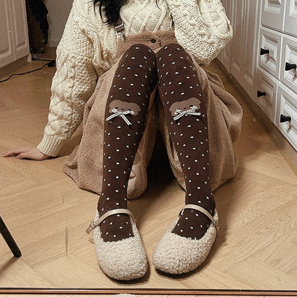 Brown over-the-knee socks with white polka dots, bear motifs and gingham bows styled with a cream coat.