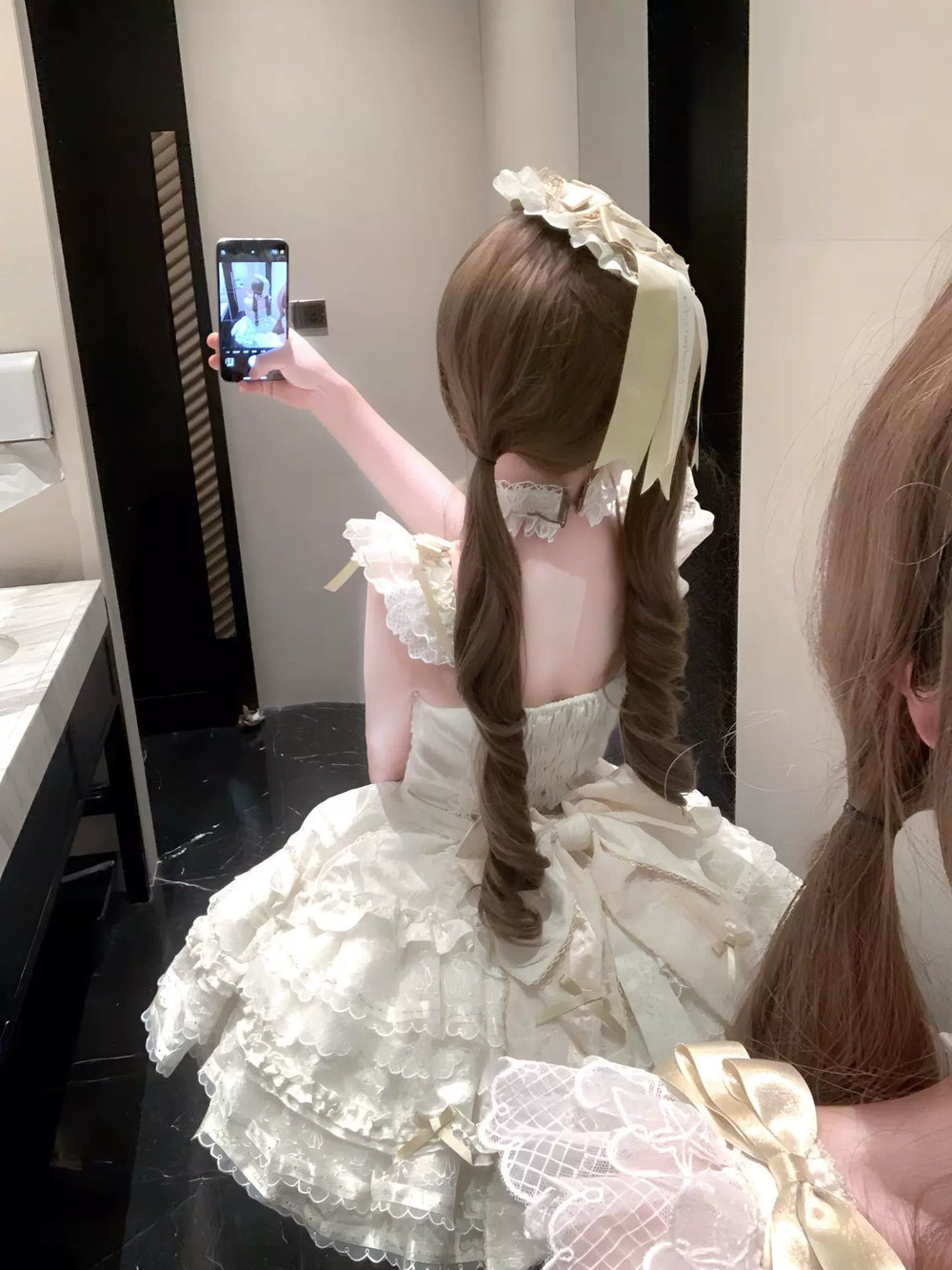 Creamy apricot Lolita dress with layered lace frills, bows, and a large train