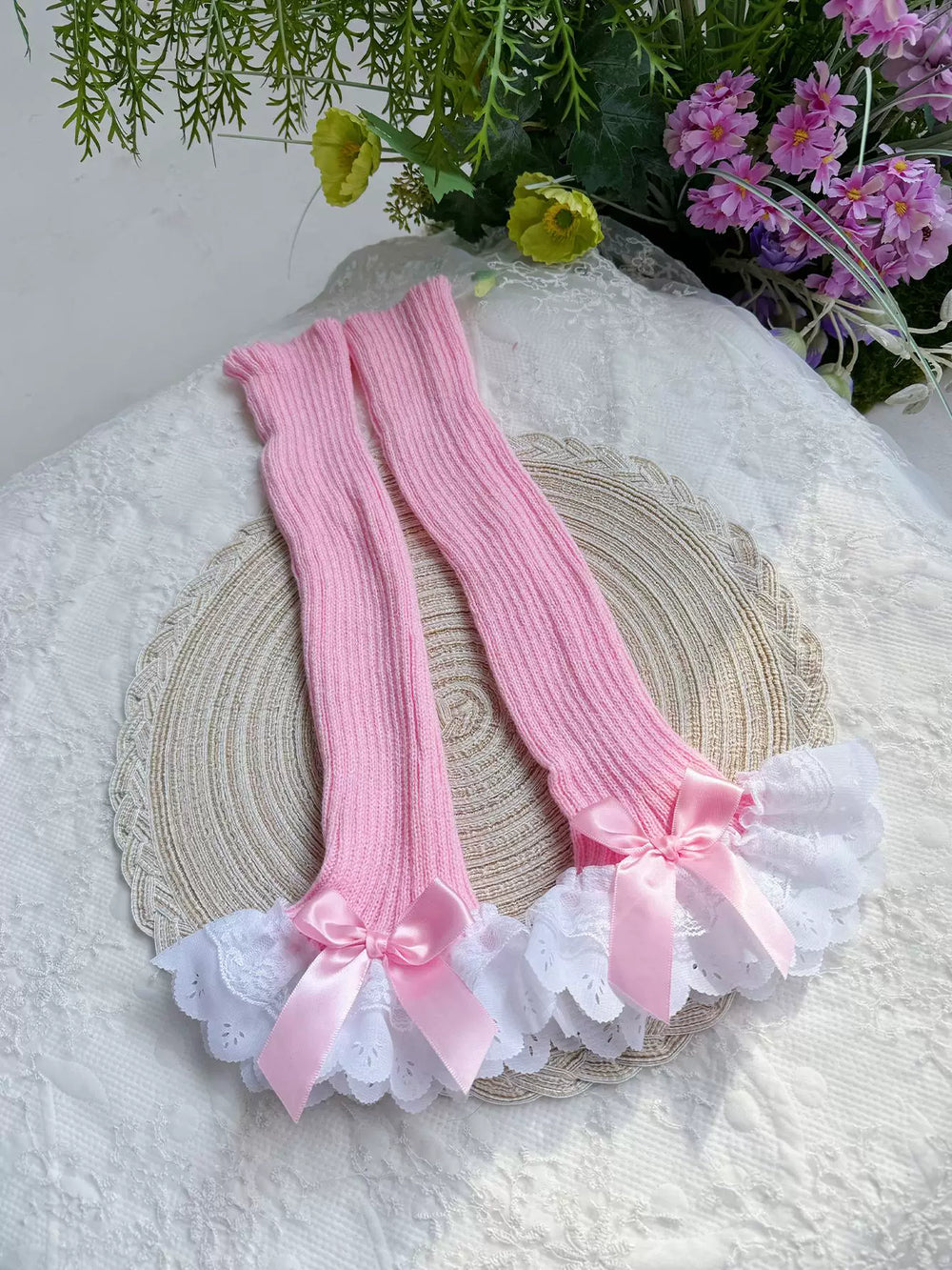 Pink ribbed leg warmers with white scalloped lace and ribbon bows