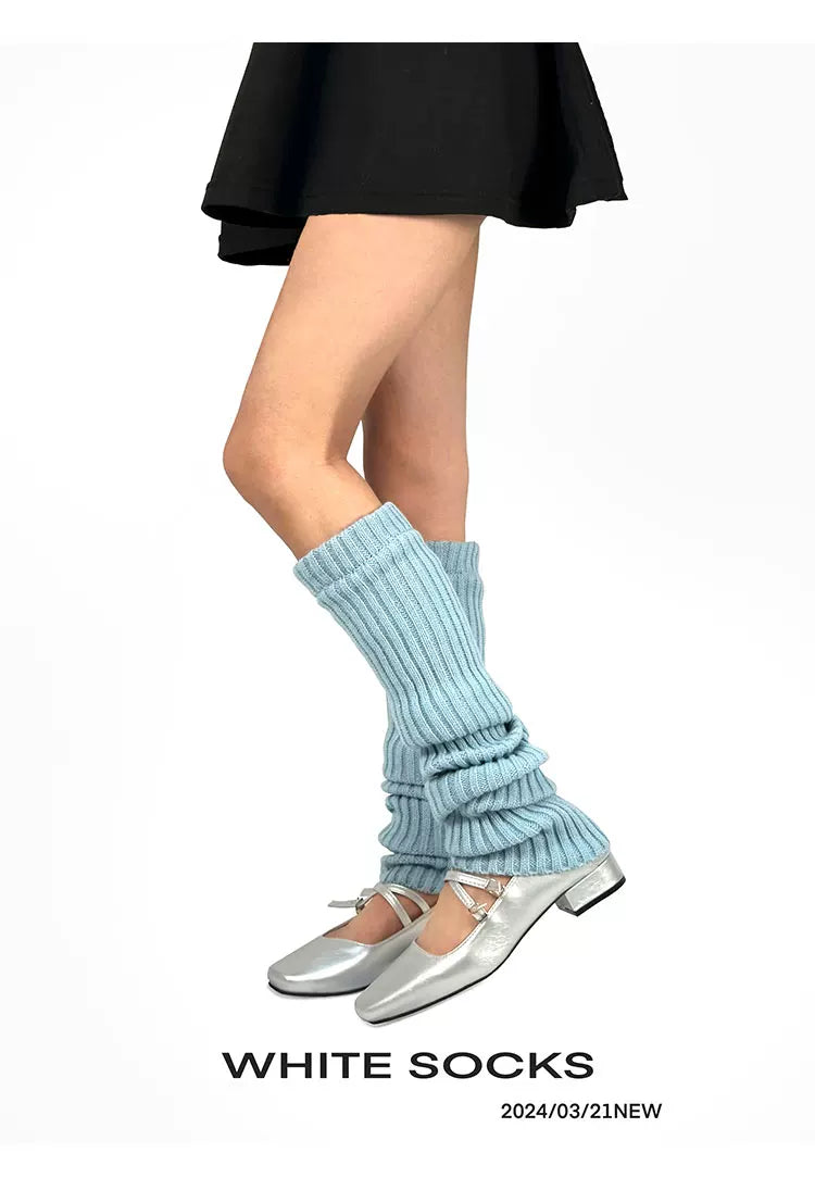 White Socks baby-blue ribbed knit leg warmers worn scrunched above silver Mary Jane shoes.