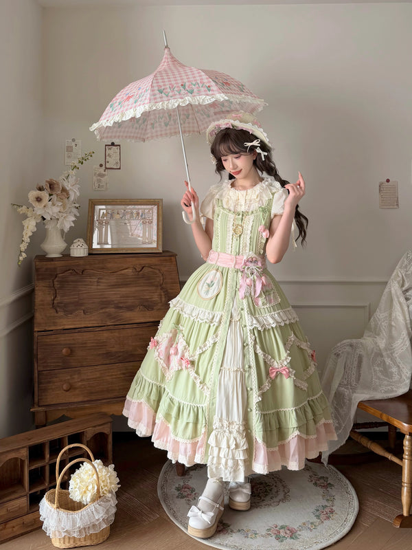 Pale green pastoral Lolita JSK with pink floral accents, white lace tiers, and a pink waist belt.