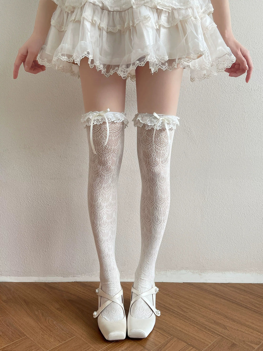 White lace over-the-knee socks with bow ties and a lace-trimmed top.