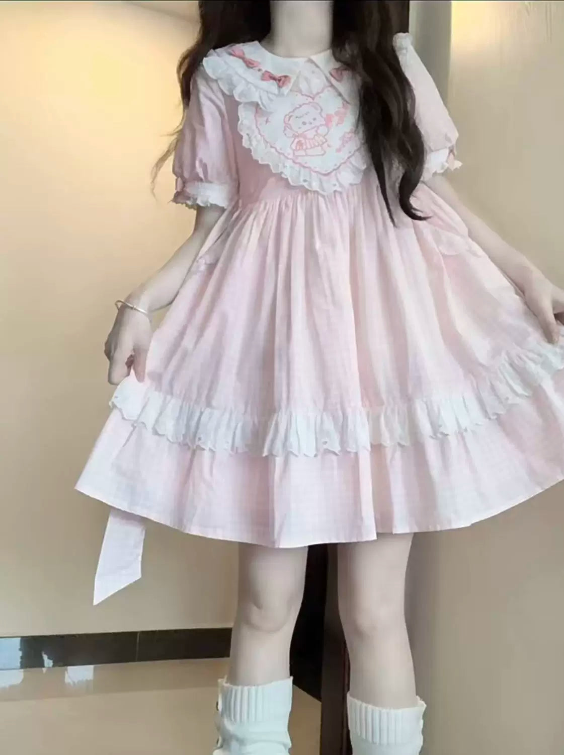 Pink checked dress with a ruffled doll collar, puff sleeves and a tiered skirt.