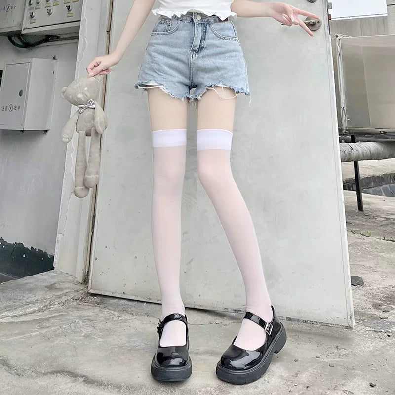 White lightly sheer over-the-knee stockings worn with denim shorts and black Mary Jane shoes.