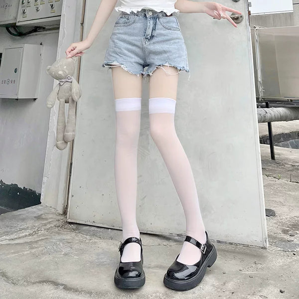 White lightly sheer over-the-knee stockings worn with denim shorts and black Mary Jane shoes.