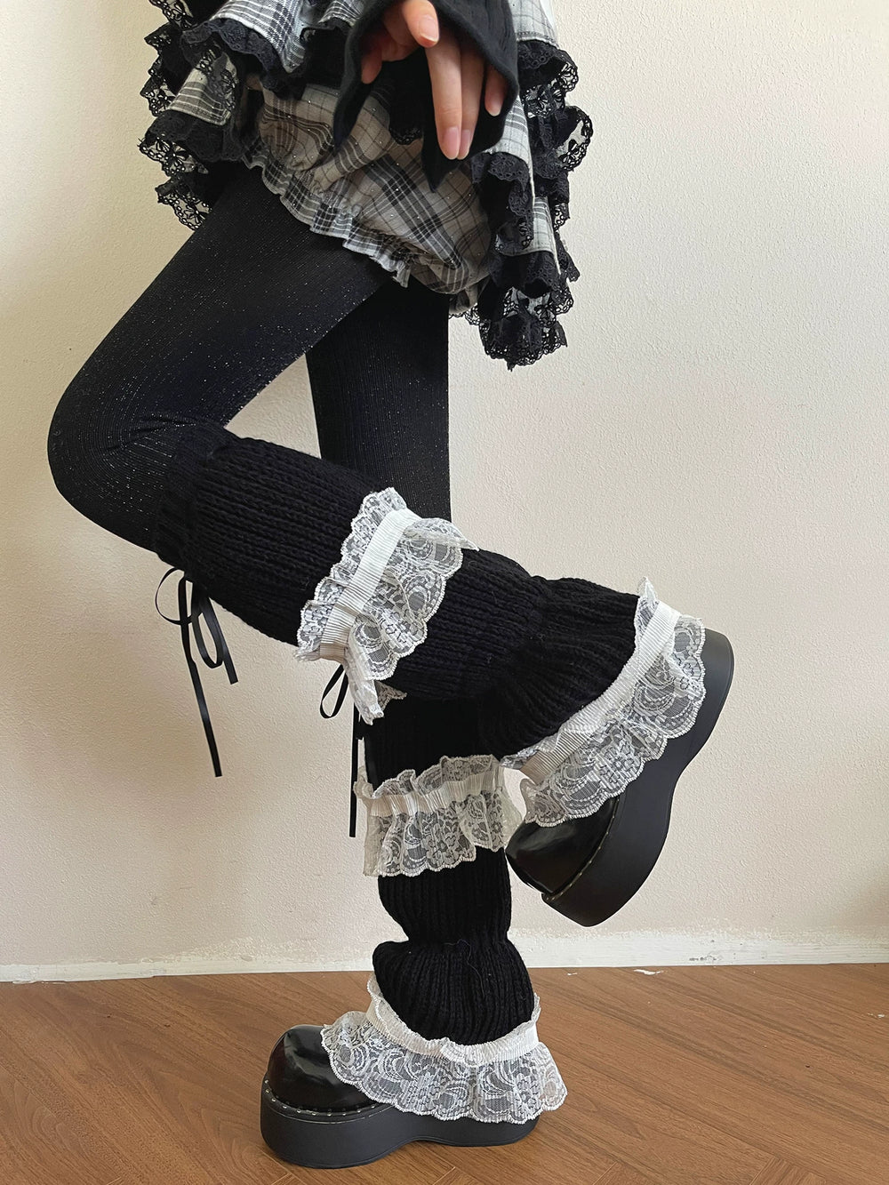 Sock Noble black lace-trimmed knit sock covers and tights styled with a plaid skirt