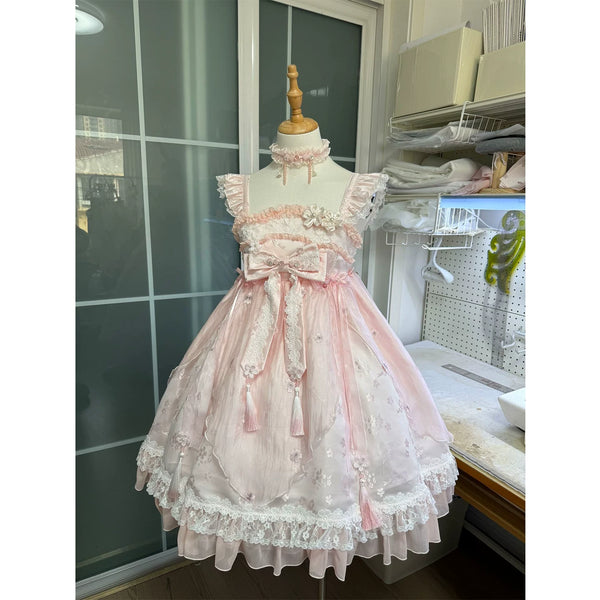 Pink high-waisted JSK dress on a mannequin with floral lace, ruffles, bows, and tassel ties