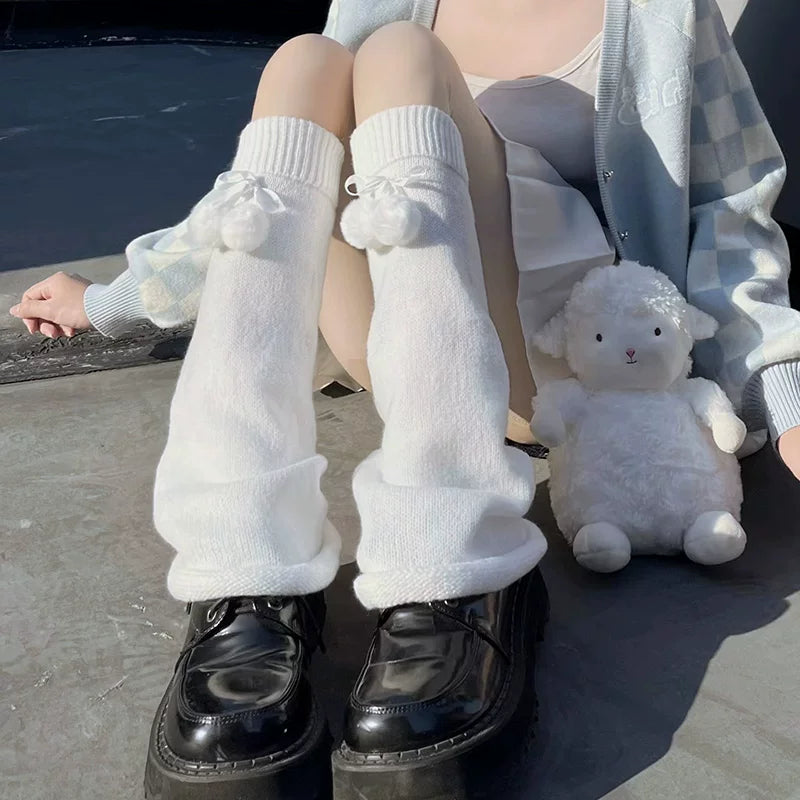 White knitted sock covers with blue pom-pom bows and long slouchy cuffs