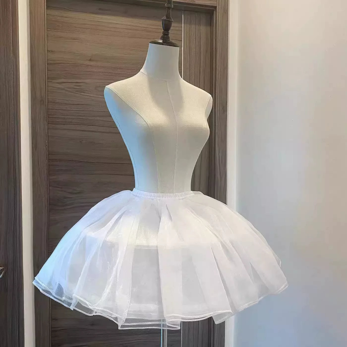 White fishbone petticoat displayed on a mannequin with a full rounded skirt silhouette.
