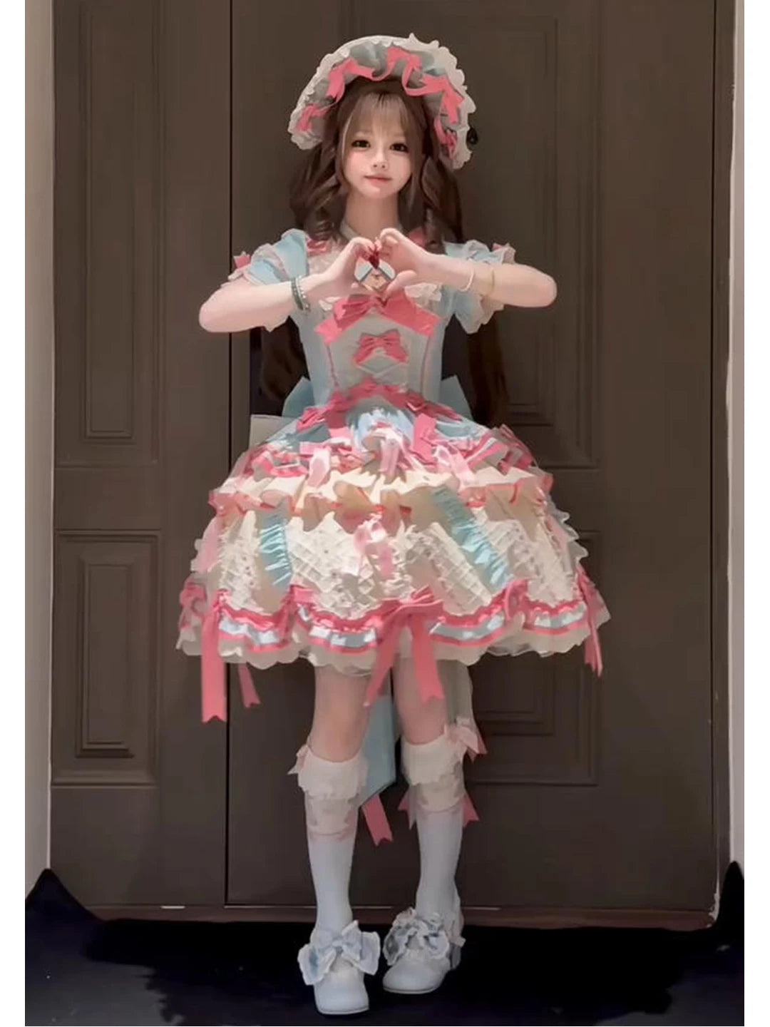 Mint, pink, and cream Lolita dress with layered ruffles, bows, a train, and matching hat.