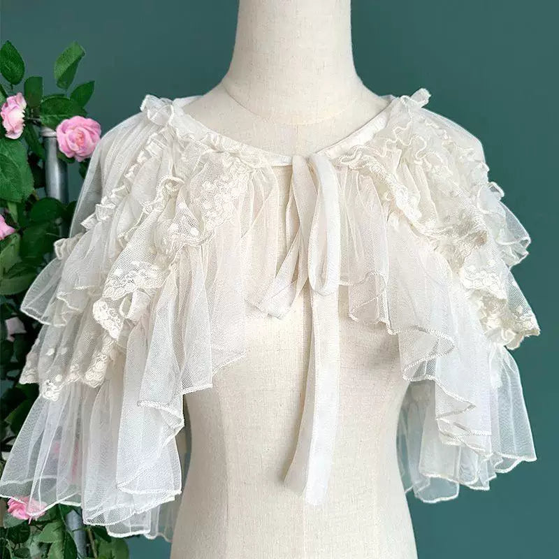 Sheer white lace-trimmed ruffle shoulder cape on a mannequin