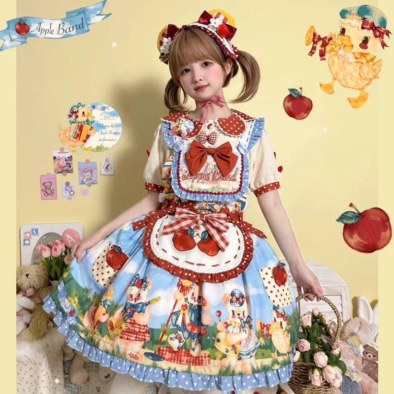 Blue strawberry-print suspender dress with red bows and apron styled outdoors