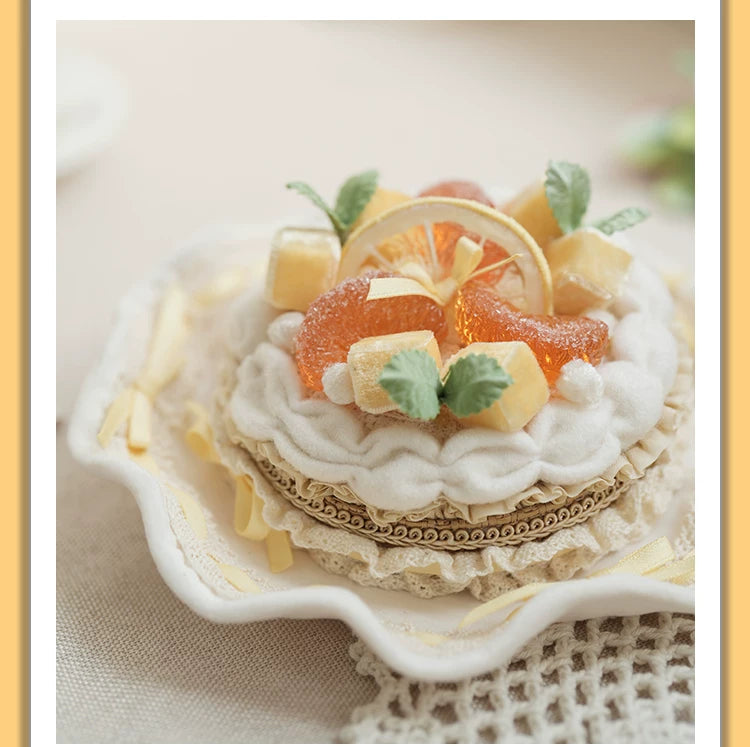Mango tart headpiece with orange fruit, cream layers, yellow accents and green leaves on a white background.