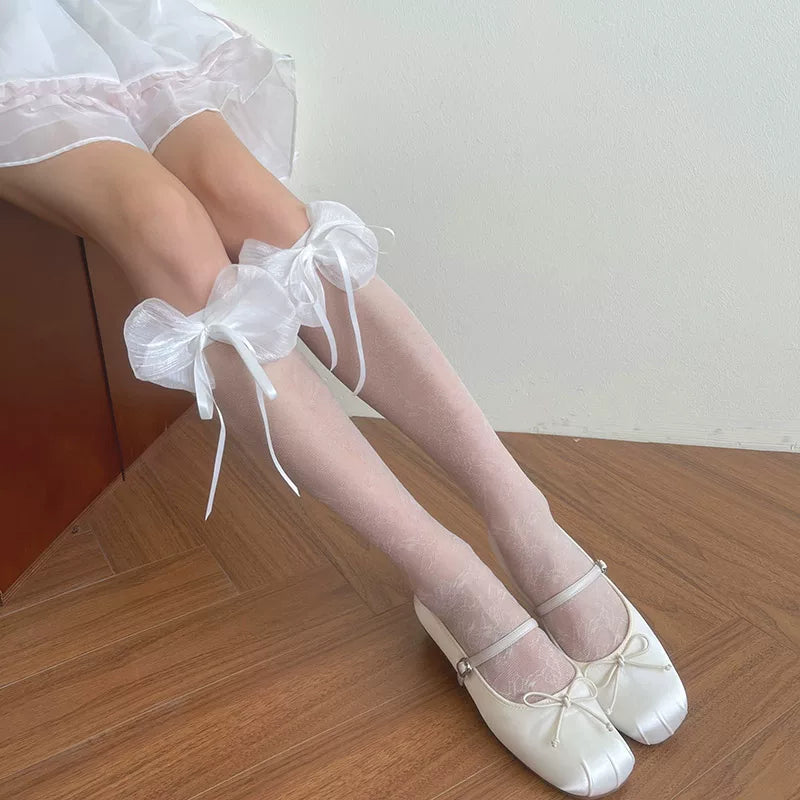 Black patterned mesh mid-calf socks with large satin bows and glossy platform shoes
