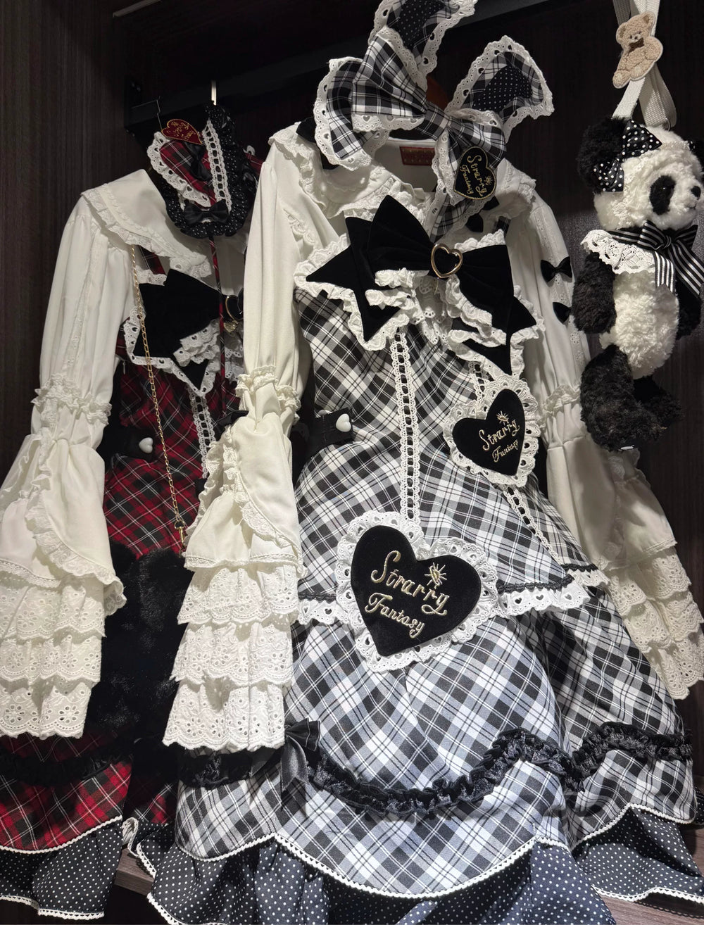 Red-black and black-white plaid Lolita dresses with lace trims, bows and heart patches displayed together.