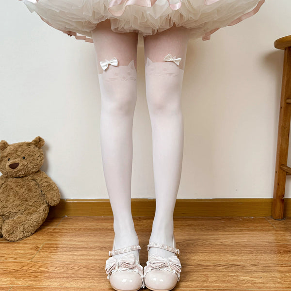 White tights with cat motifs and bows styled beneath a layered skirt.