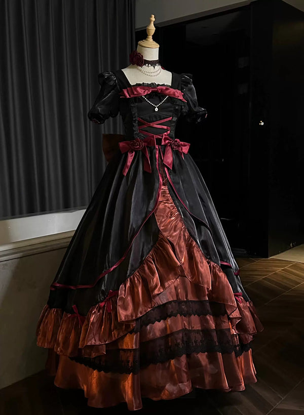 Black-and-deep-red one-piece dress with rose accents, bows, layered ruffles, and a train on a mannequin.