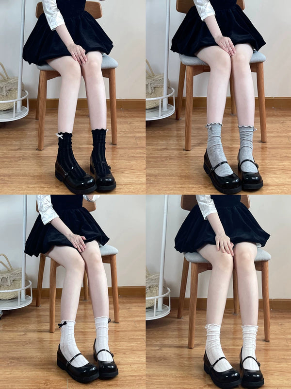 White ribbed mid-calf socks with frilled cuffs and black bows
