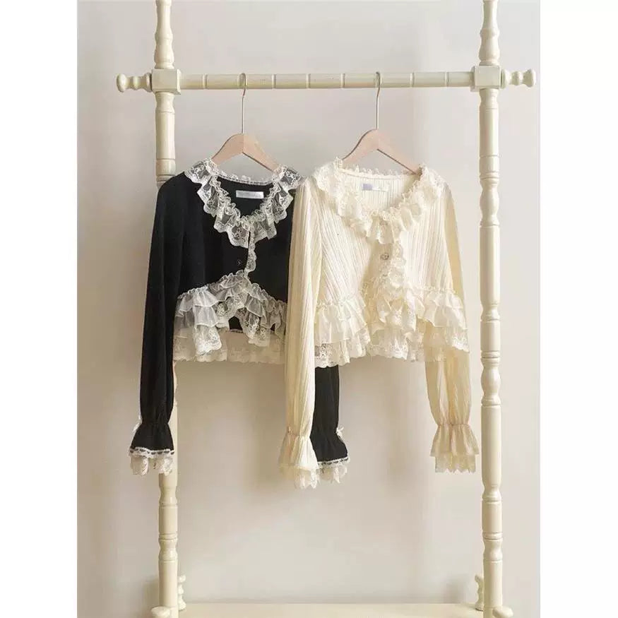 Off-white and black lace-trimmed Lolita cardigans hanging on a clothing rack