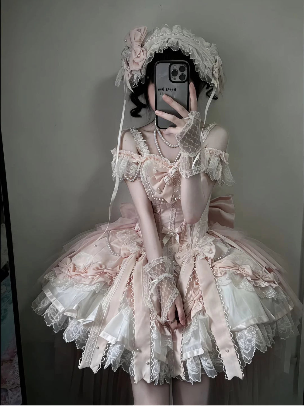 Pink-and-white ballet-inspired Lolita dress with layered lace, bows, pearl strands and trailing hem