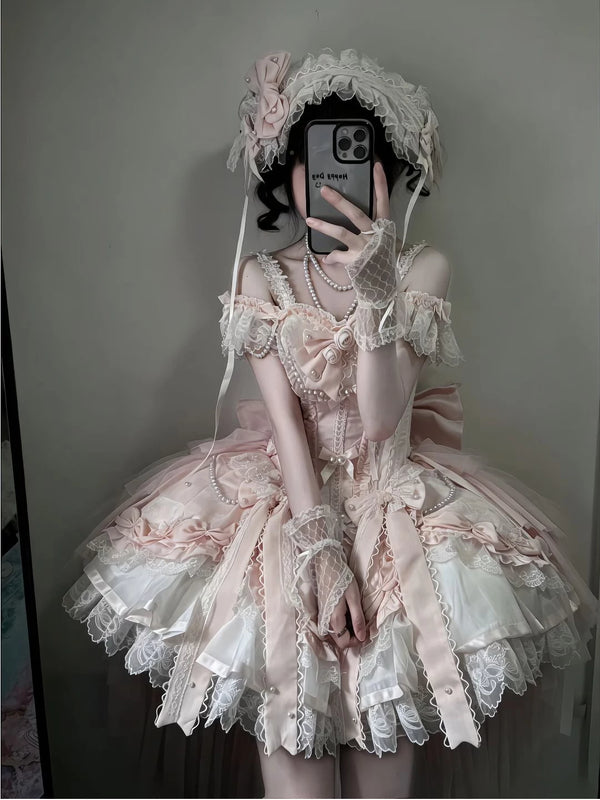 Pink-and-white ballet-inspired Lolita dress with layered lace, bows, pearl strands and trailing hem
