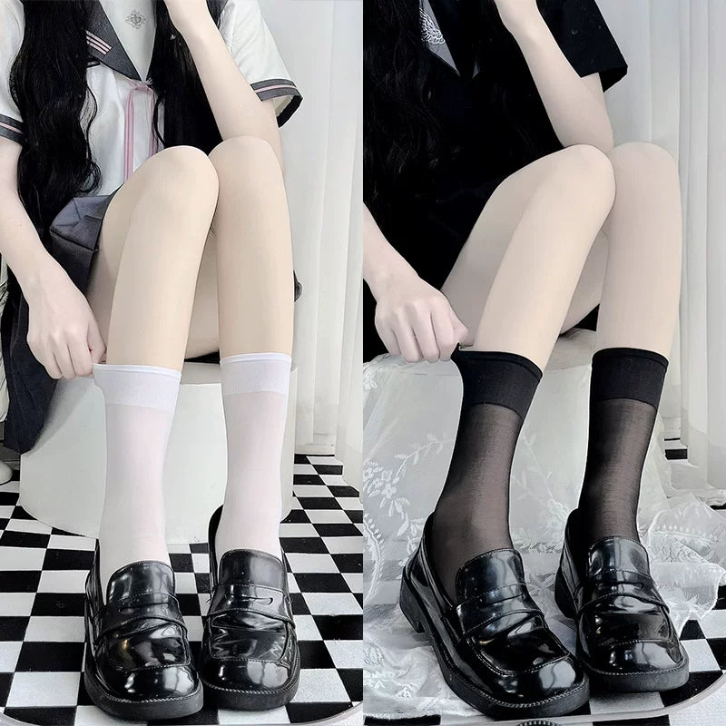 White and black sheer mid-calf socks styled with glossy black loafers.