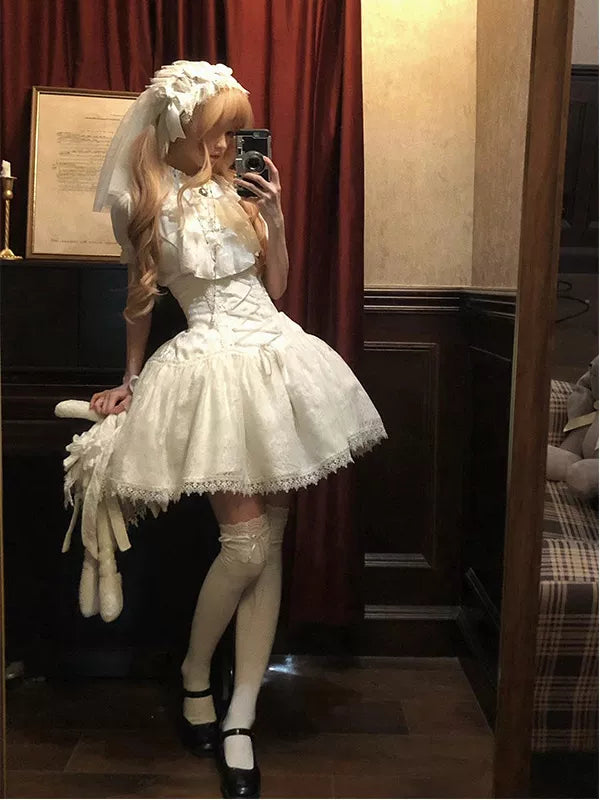 Model wearing a white Gothic blouse, bib and short skirt set.