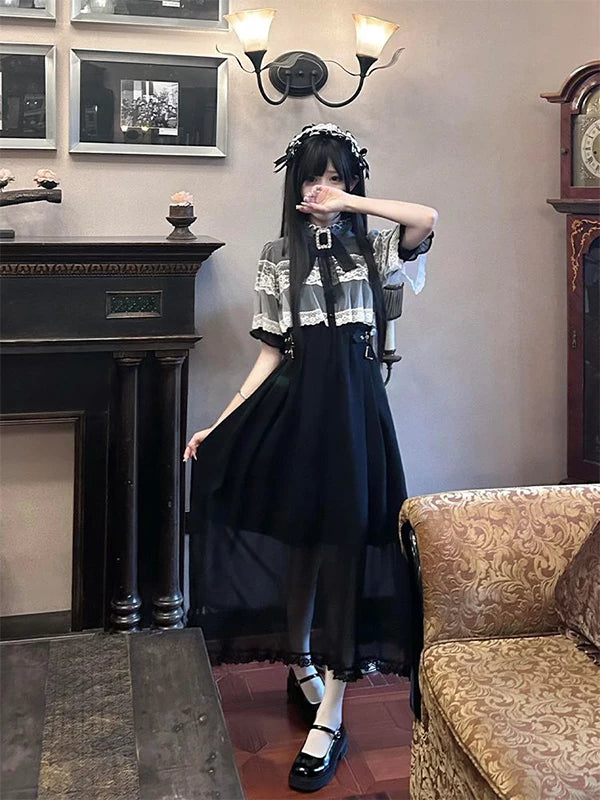 Front view of black Gothic Lolita dress with sheer lace capelet and brooch