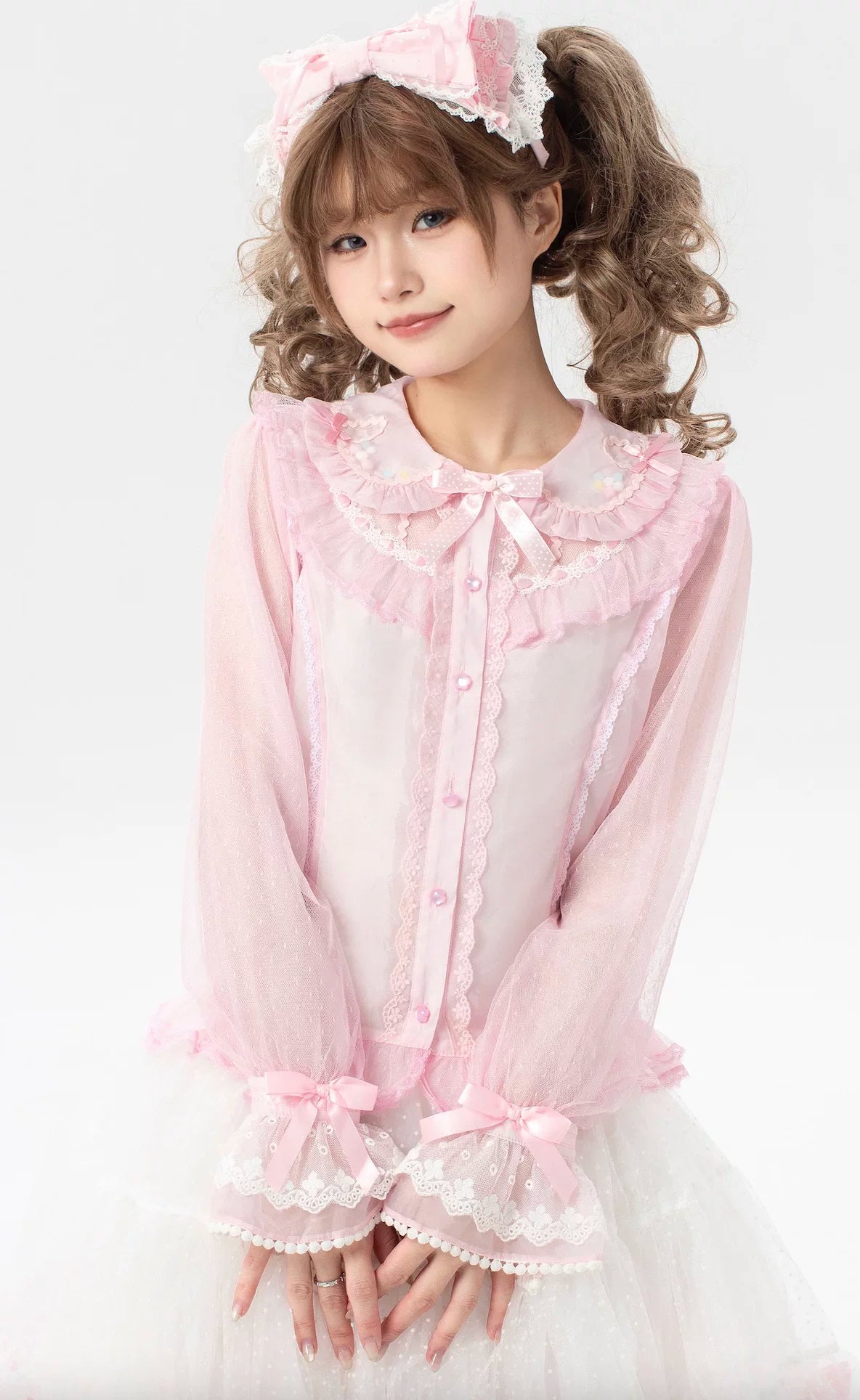 Pink bow and pearl accessory details shown against a pastel Lolita blouse.
