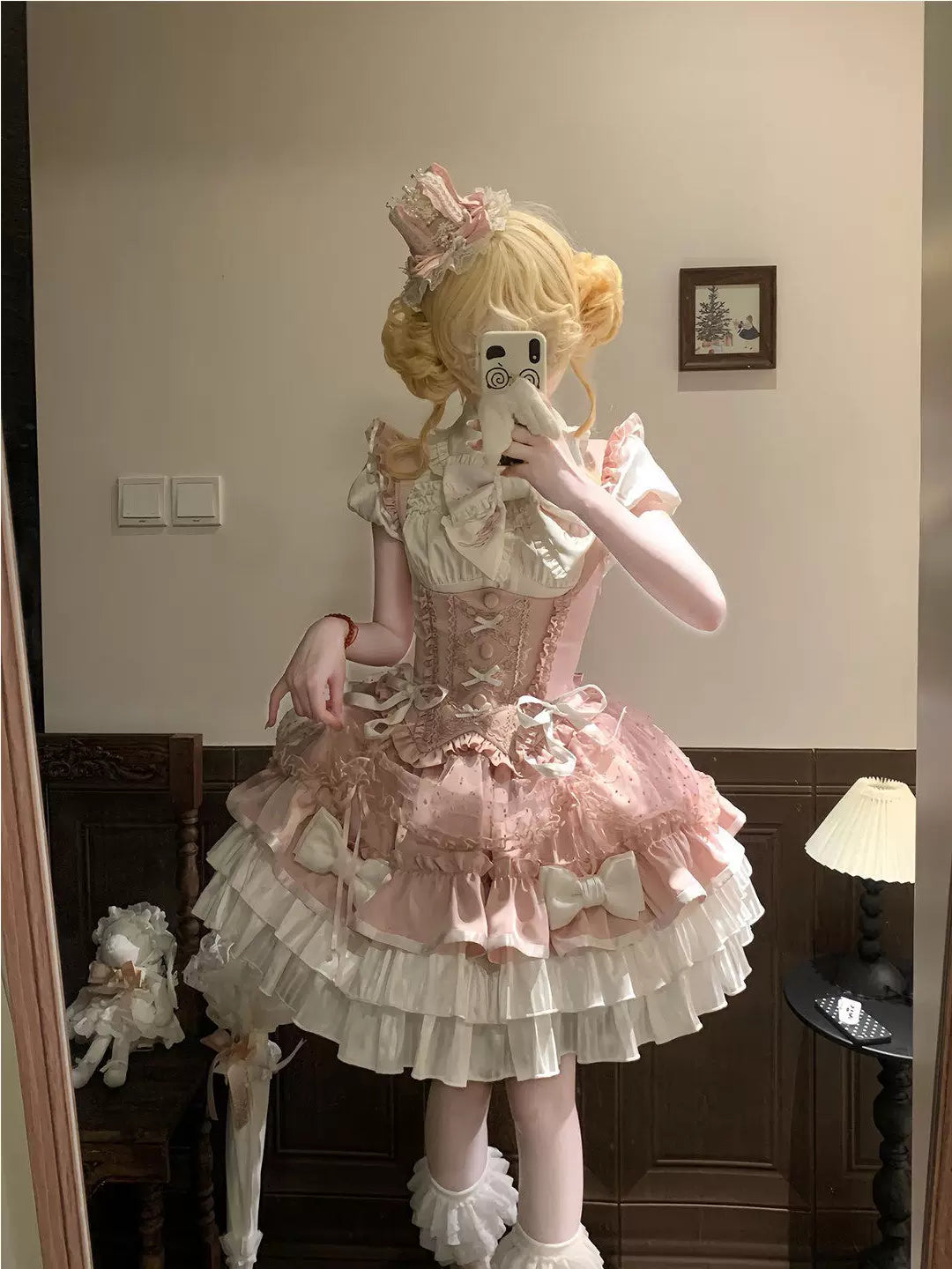 Model wearing a pink and white ruffled Lolita shirt and bust-support skirt coordinate with bows.