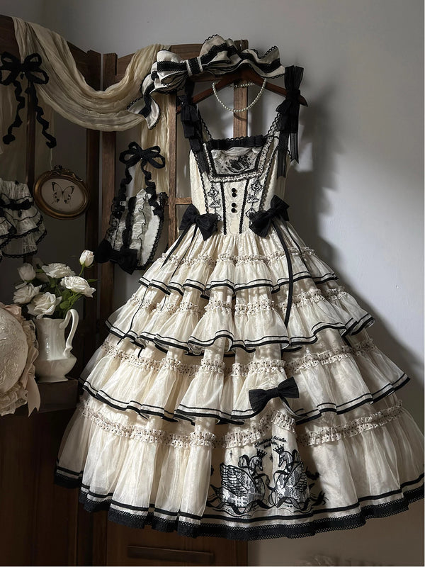 Ivory and black Creamy JSK dress with tiered ruffles, swan embroidery, black bows, and a matching headpiece.