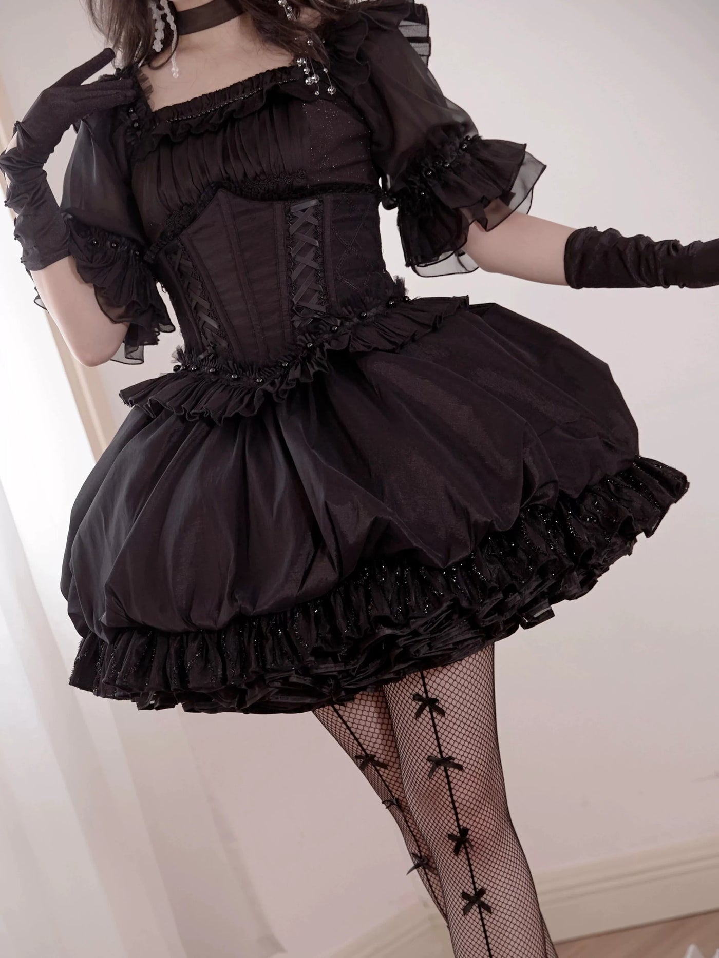 Moro Twins black Lolita outfit with fitted waist, sheer sleeves and layered ruffles