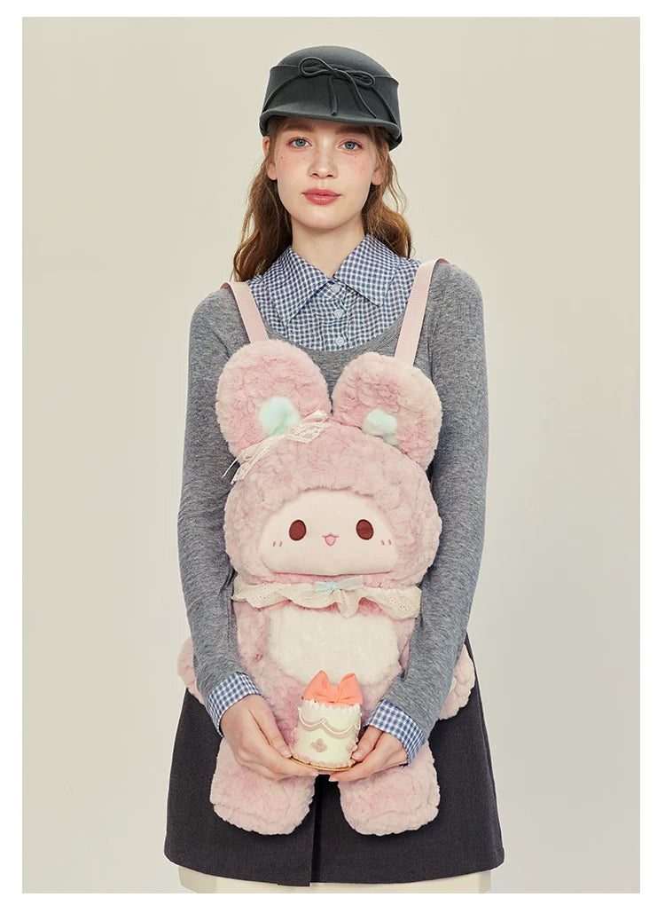 Pink rabbit plush backpack worn over a blouse.