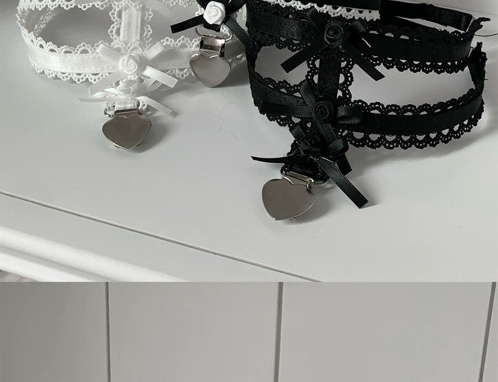 White and black sock clips with layered roses, lace trim, ribbon bows and heart-shaped charms.