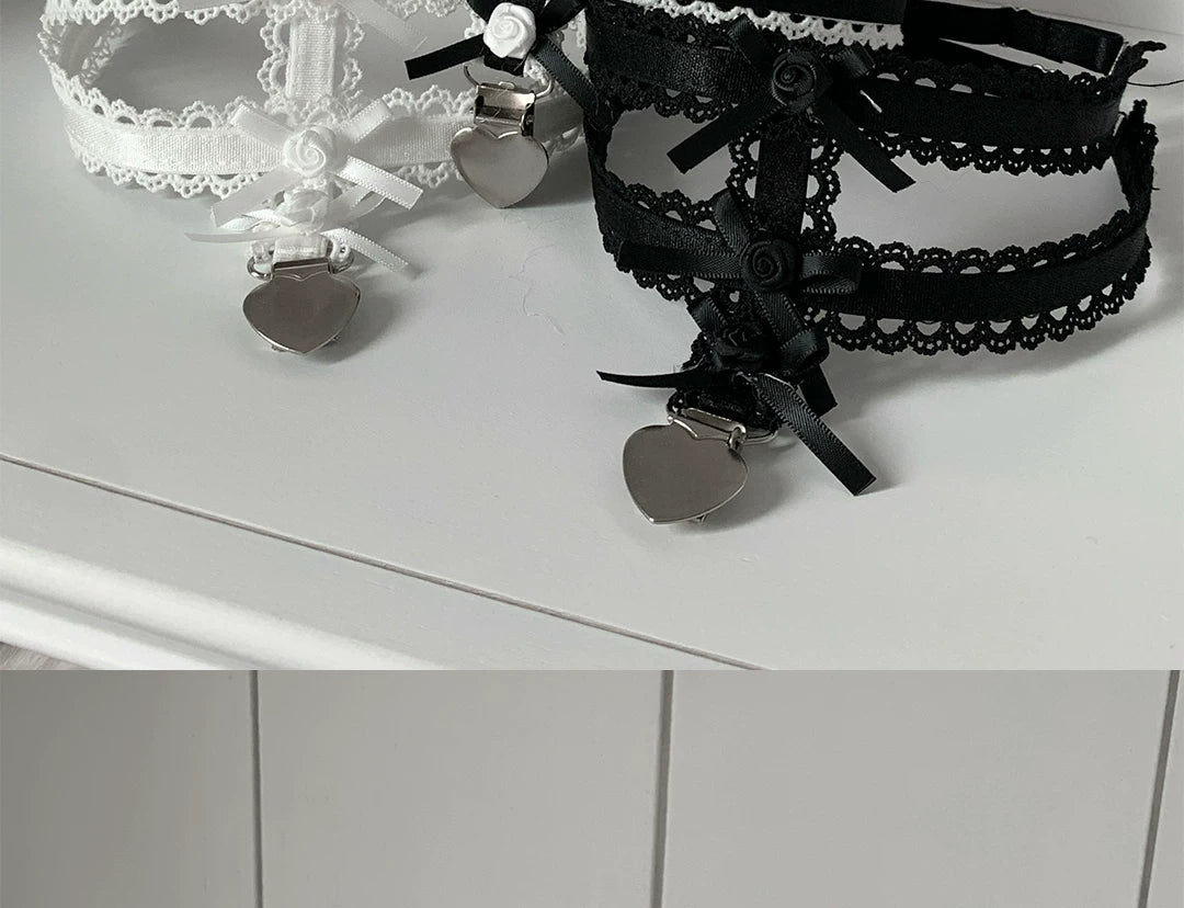 White and black sock clips with layered roses, lace trim, ribbon bows and heart-shaped charms.