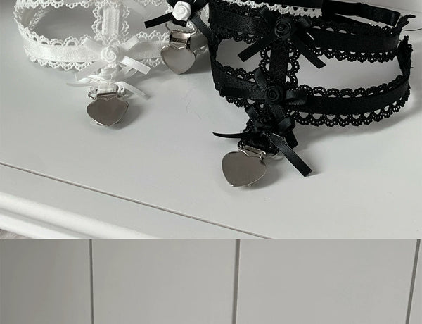 White and black sock clips with layered roses, lace trim, ribbon bows and heart-shaped charms.
