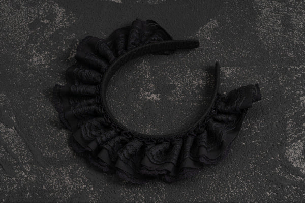 Black lace Gothic Lolita headband photographed on a dark background.