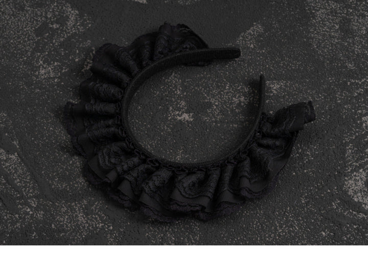 Black lace Gothic Lolita headband photographed on a dark background.