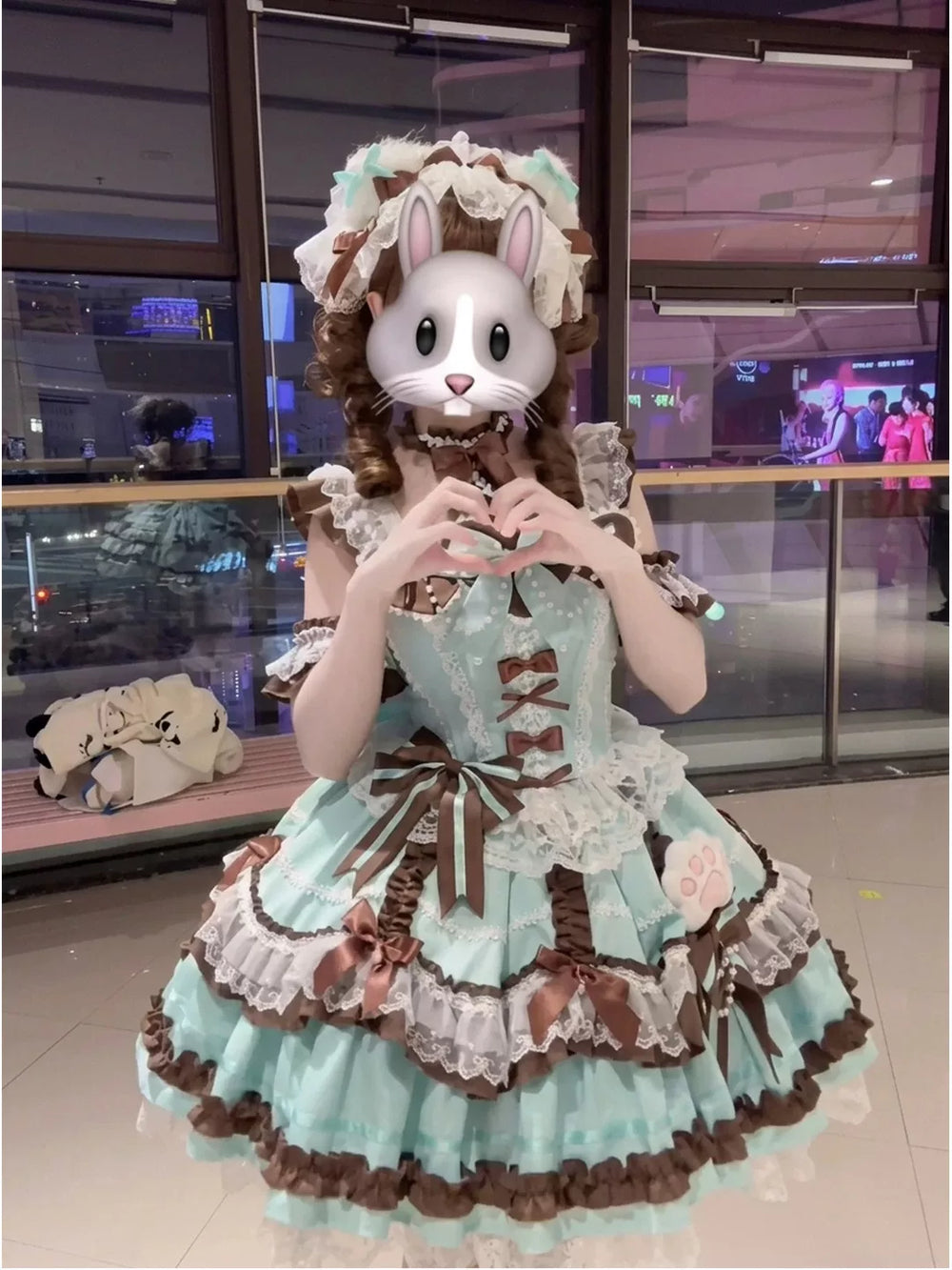 Model wearing a mint-and-brown JSK dress with lace, bows and paw-print accents; face obscured.