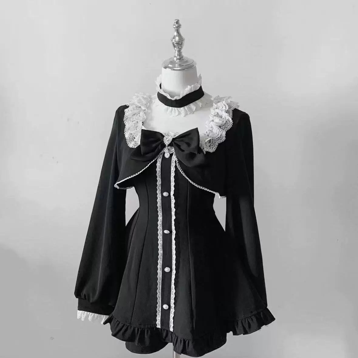 Black long-sleeve faux two-piece set with white lace collar on a mannequin