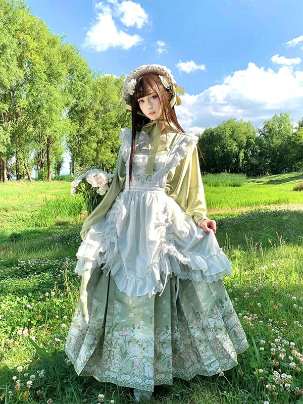Model wearing a pale green standing-collar top, floral mamian skirt and ruffled skirt cover outdoors.