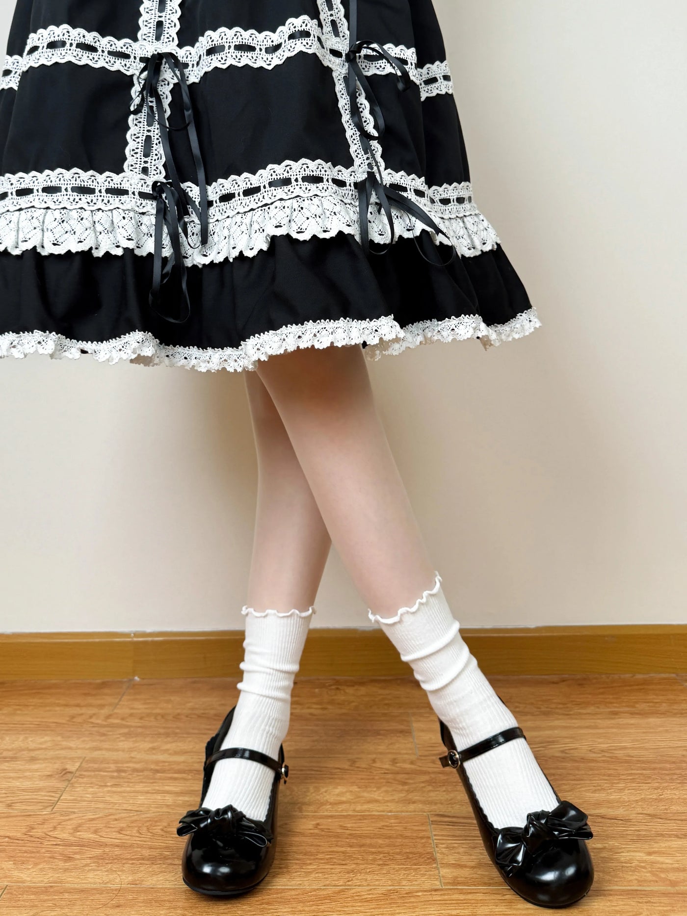 White scrunched socks with scalloped lace trim styled with black strap shoes