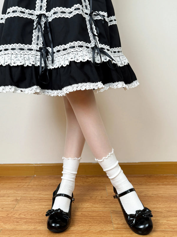 White scrunched socks with scalloped lace trim styled with black strap shoes