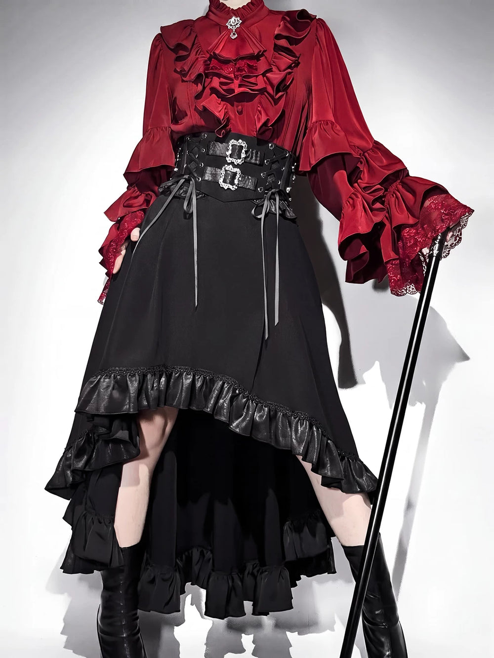 Burgundy ruffled long-sleeve blouse with black corset-style skirt and layered hem trim